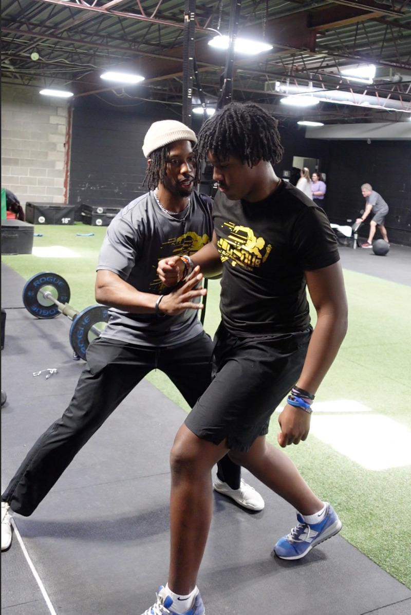 Coach C-Dub training a client in the gym